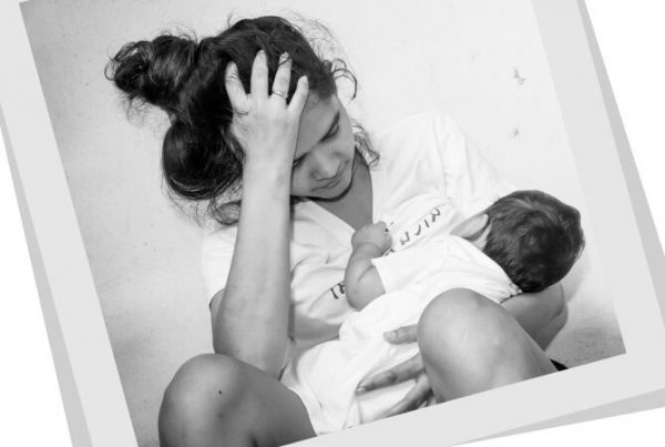 young woman with child, holding her head in despair