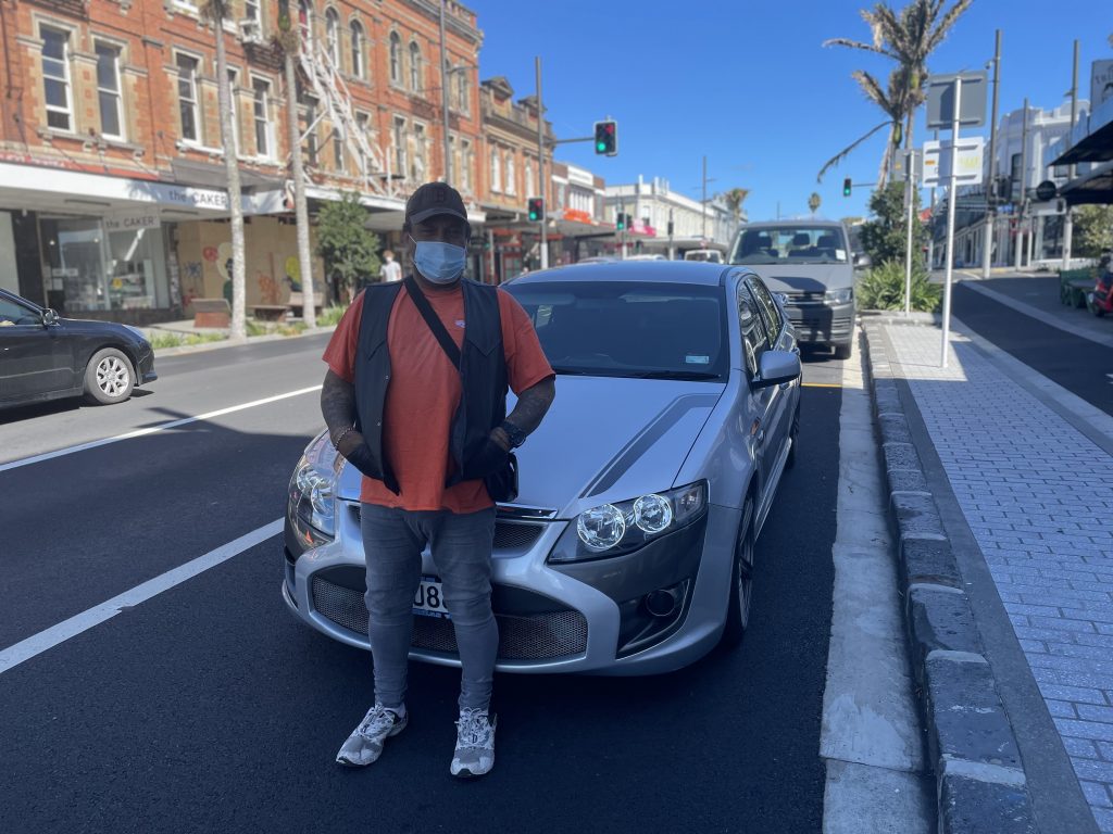 Thomas Peri standing in front of a car