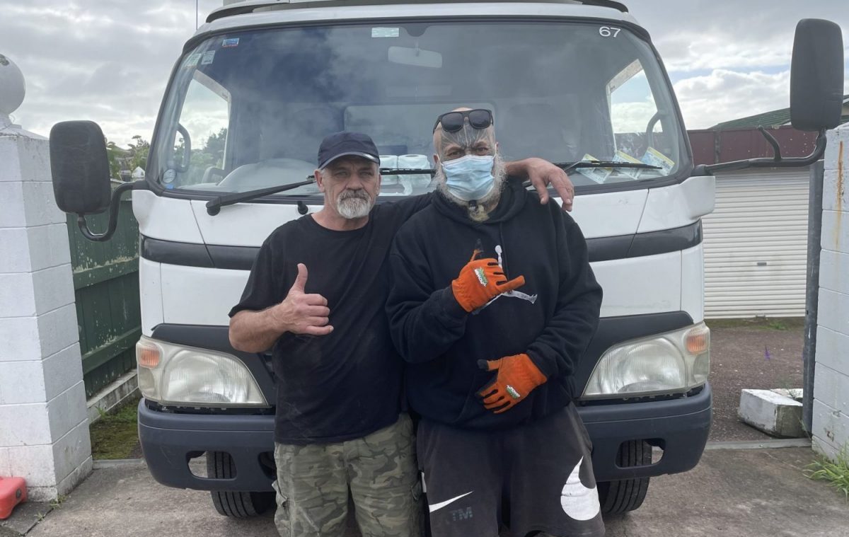 two men standing in front of a truck